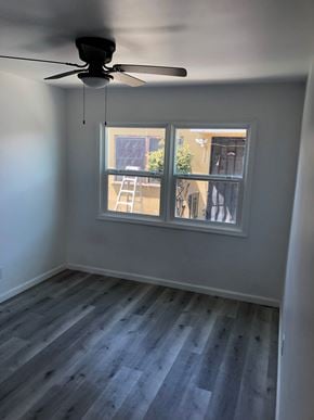 San Diego apartment for rent - A room with a ceiling fan and a window with a ladder.