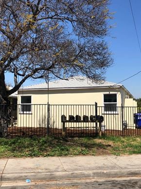 San Diego apartment for rent - A house with a black fence and a tree in front of it.