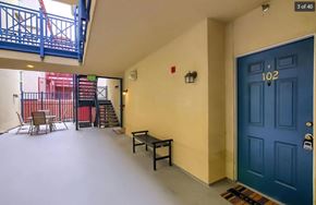 Denver house for rent - a room with a blue door and a balcony with chairs and tables