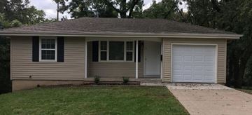 Kansas City house for rent - A small house with a white garage door.