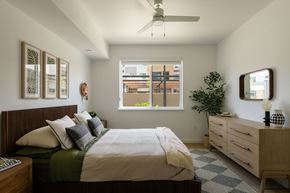 Sacramento apartment for rent - A bedroom with a bed, dresser, and window.