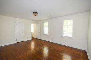 Midlothian house for rent - an empty living room with wood floors and white walls