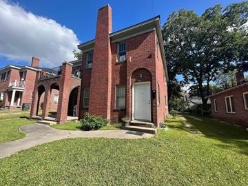 Greenville apartment for rent - A red brick building with a white door and windows.