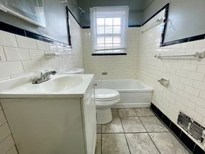 Louisville apartment for rent - A white sink and toilet in a bathroom with black and white tiles.