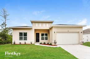 Palm Bay house for rent - a beige house with a lawn and a garage door