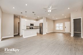Palm Bay house for rent - an empty living room with a kitchen and a ceiling fan