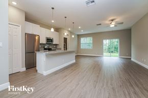 Palm Bay house for rent - an open kitchen and living room with a kitchen island and stainless steel appliances