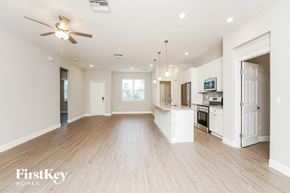 Palm Bay house for rent - an empty living room and kitchen with a ceiling fan