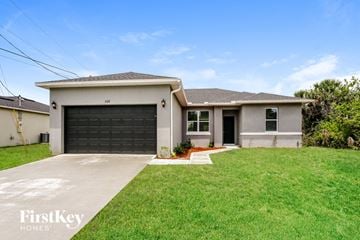 Palm Bay house for rent - a white house with a black garage door