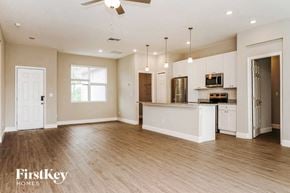 Palm Bay house for rent - an open kitchen and living room with a kitchen island and white cabinets