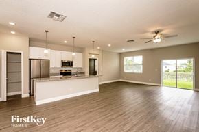 Palm Bay house for rent - an open kitchen and living room with a kitchen island and stainless steel appliances