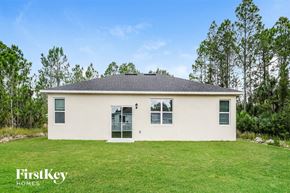 Palm Bay house for rent - a cream colored house with green grass and trees