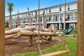 Lakeland apartment for rent - A playground with a swing set in front of a building.