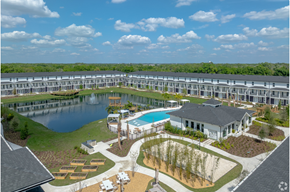 Lakeland apartment for rent - A large building complex with a pool and a pond.