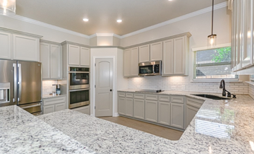 Killeen house for rent - a kitchen with white cabinets and a marble counter top