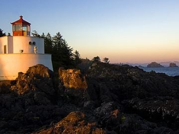 St. Louis house for rent - A lighthouse stands on a rocky outcrop by the sea.