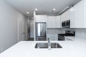 Hackensack apartment for rent - a kitchen with white counter tops and a stainless steel refrigerator