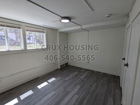 Great Falls apartment for rent - A room with a white ceiling and a window with a view of a car and trees outside.
