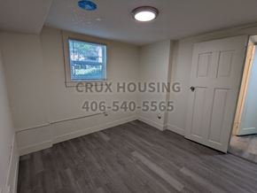 Great Falls apartment for rent - A room with a window and a door, with the text "CRUX HOUSING" and a phone number on the wall.