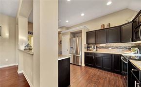 Killeen house for rent - a kitchen with black cabinets and a stainless steel refrigerator