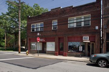 Pittsburgh apartment for rent - a red brick building on a street corner with a stop sign