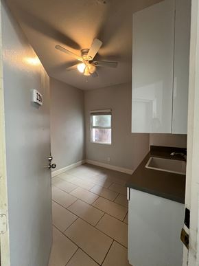 Oakland apartment for rent - A kitchen with a white fridge and a window.