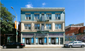 Oakland apartment for rent - A black car is parked on the street in front of a blue building.