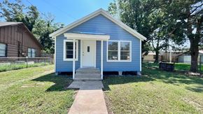Bay City house for rent - a small blue house with a sidewalk in front of it