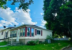Belding house for rent - a white house with red trimmed windows on a lawn