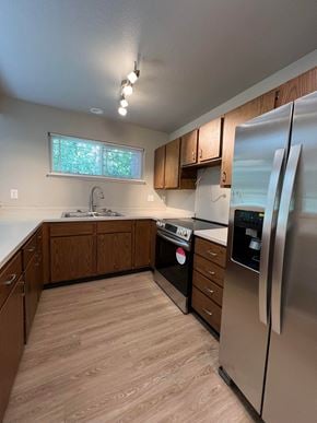 Fort Collins apartment for rent - an empty kitchen with stainless steel appliances and wooden cabinets