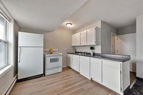 Monticello apartment for rent - a kitchen with white cabinets and appliances and a window