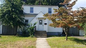 Carteret house for rent - a white house with a sidewalk in front of it