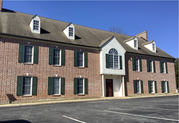 Kennett Square apartment for rent - A red brick building with green shutters and a white trim.