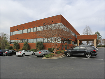 Lexington apartment for rent - a large brick building with cars parked in a parking lot