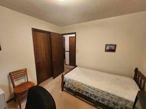 Norman house for rent - a bedroom with a bed and a chair and a closet