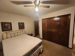 Norman house for rent - a bedroom with a bed and a ceiling fan and a closet