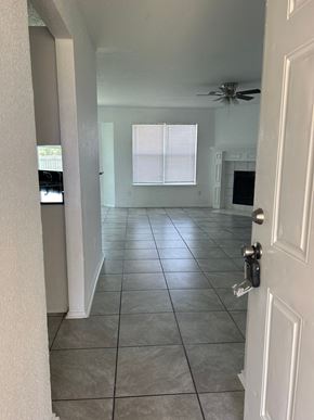 Killeen house for rent - an empty living room with a tile floor and a ceiling fan