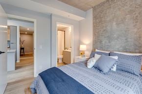 Edmonton apartment for rent - a bedroom with a blue and white bed and a bathroom