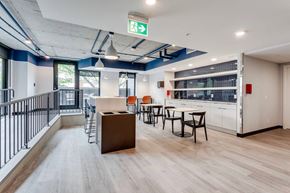 Edmonton apartment for rent - a dining area with tables and chairs and a counter in the middle of a room