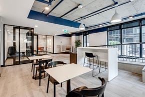 Edmonton apartment for rent - a communal area with tables and chairs in a modern office space