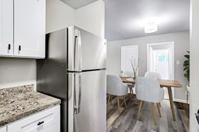 San Antonio apartment for rent - A kitchen with a refrigerator, cabinets, and a dining table.