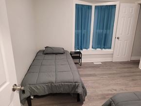 Hamilton house for rent - a bedroom with a bed and a window with blue curtains