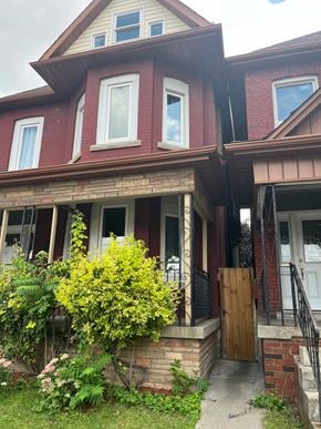 Hamilton house for rent - a red brick house with a front porch and a wooden door