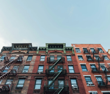 Brooklyn apartment for rent - A red brick building with black fire escapes.
