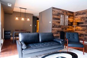 New Carrollton apartment for rent - a living room with a leather couch and a wooden accent wall