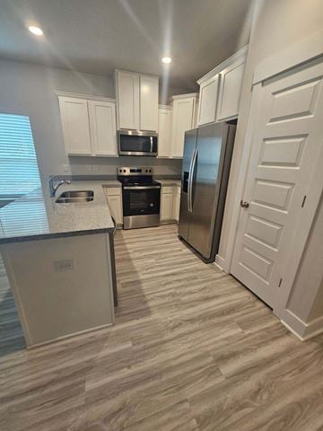 Pensacola house for rent - a kitchen with stainless steel appliances and white cabinets