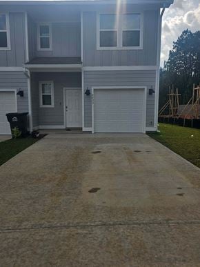 Pensacola house for rent - a driveway in front of a house with a white garage door