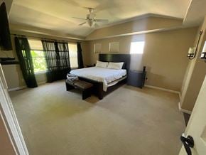 Castle Pines house for rent - a bedroom with a bed and a ceiling fan