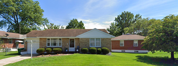 St. Louis house for rent - a small brick house with a lawn and trees