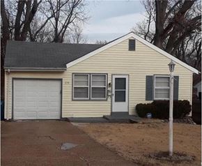 Ferguson house for rent - a yellow house with a white garage door